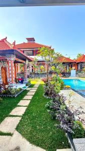 a resort with a swimming pool and a yard at Villa Jepun Lovina in Lovina