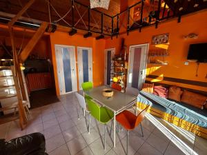 una sala da pranzo con pareti arancioni, tavolo e sedie di Mediterran Rose Apartments a Zamárdi