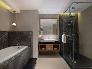 ein Badezimmer mit Badewanne, Waschbecken und Dusche in der Unterkunft Santika Premiere Bintaro in Serpong