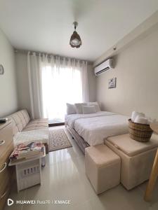 a bedroom with a large bed and a couch at The Ecru Suite in Lapu Lapu City