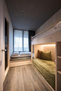 a bedroom with two bunk beds and a window at AKI Family Resort PLOSE in Bressanone +70 photos
