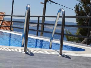 a metal railing next to a swimming pool at Villa Marina in Omiš