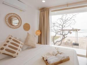 a bedroom with a white bed with a large window at Stories Stay pool villa Huahin พูลวิลล่าหัวหิน ติดทะเล in Sathani Khao Tao +50 photos