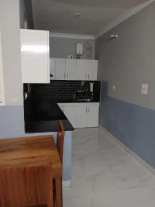 a kitchen with white cabinets and a wooden table at Jaiswal Home Stay in Rishīkesh +48 photos