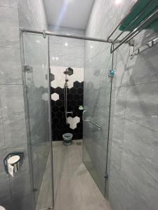 a bathroom with a shower with a toilet in it at Lauren Homestay in Tây Ninh