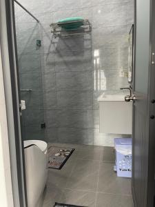 a bathroom with a toilet and a glass shower at Lauren Homestay in Tây Ninh +2 photos