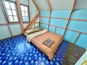 a bed in a room with blue walls and windows at วัชระ&ภัทรมน พูลวิลล่า รีสอร์ท จันทบุรี in Ban Bang Krachai