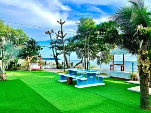 a park with a blue bench on green grass at วัชระ&ภัทรมน พูลวิลล่า รีสอร์ท จันทบุรี in Ban Bang Krachai