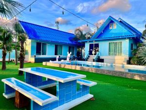a blue house with a swimming pool in front of it at วัชระ&ภัทรมน พูลวิลล่า รีสอร์ท จันทบุรี in Ban Bang Krachai +14 photos