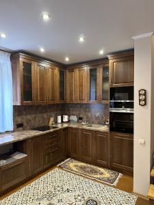 a kitchen with wooden cabinets and a stove top oven at Будинок у горах in Turʼya Paseka