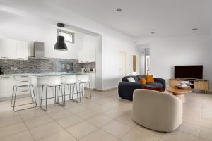 a living room with a couch and a kitchen at Villa Rocabella with heated pool & jacuzzi in Lindos in vlicha