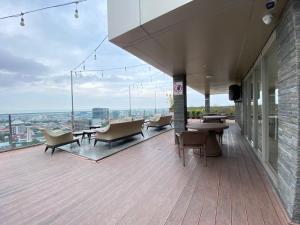 a building with chairs and tables on a balcony at Spacious Combined Studio Apartment at Warhol (W/R) Residence By Travelio in Semarang