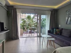 a living room with a couch and a balcony with a table at Studio in city in Fuengirola