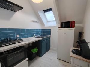 a kitchen with a sink and a refrigerator and a window at résidence le parc in Condé-sur-Noireau +2 photos