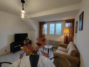 a living room with a table and a couch at résidence le parc in Condé-sur-Noireau