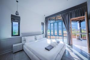 a living room with a white couch and a large window at BangTao 6-bedroom villa 18 meters, competition-grade swimming pool, industrial style design aesthetic, gaming and entertainment floor, suitable for family vacations and group gatherings in Laguna Phuket