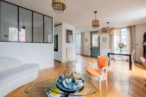 a living room with a glass table and chairs at Veeve - Seagull’s House in Boulogne-Billancourt