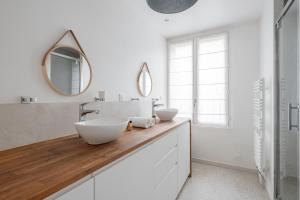Un baño con dos lavabos y un espejo. en Veeve - Seagull’s House, en Boulogne-Billancourt 33 fotos más