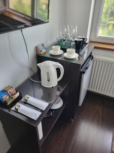 a bathroom with a sink and a table with glasses at Pokoje Pod 22 Bis in Łebcz