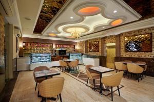 a restaurant with tables and chairs in a room at Royal Kingdom Sarovar Portico Pilibhit in Pīlībhīt