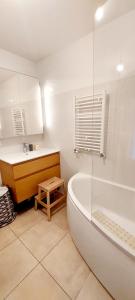 a white bathroom with a tub and a sink at Chic & Cosy apartment - 60m2, 3 rooms in Asnières-sur-Seine