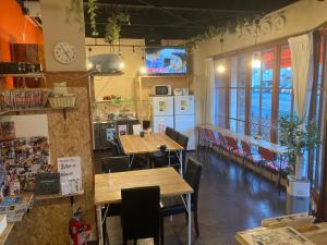 a restaurant with tables and chairs and a clock on the wall at Guesthouse LuLuLu 無料朝食&夕食ｶﾚｰ 街まで電車8分 ﾛｰｿﾝ隣 in Kochi
