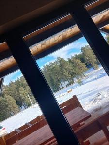 a view of a snow covered field from a window at ROMANIJA vikendice in Koprivice