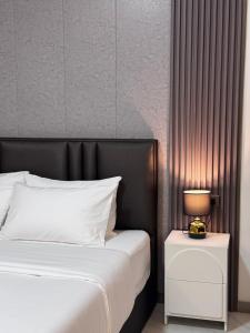 a bedroom with a bed and a night stand with a lamp at Maesai Bliss Residence in Ban Pa Yang