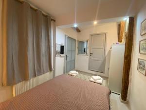 a small room with a bed and a refrigerator at Liric Studio in Sibiu