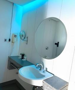 a bathroom with a white sink and a mirror at Hotel Bonaparte Moderno e versátil in Brasilia