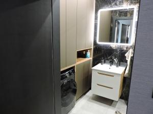 a bathroom with a washing machine and a sink at Centro Residence in Kluczbork