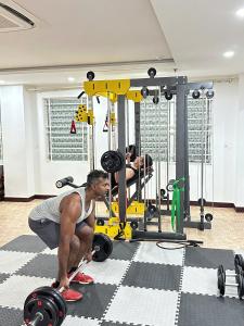 a woman squats in a gym with weights at Star Hotel and Spa Danang in Danang