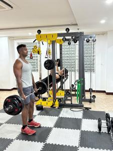 a man holding a barbell in a gym at Star Hotel and Spa Danang in Danang
