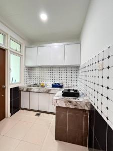 a kitchen with white cabinets and a counter top at Homestay Kubang Kerian Pinggiran Universiti HUSM, Kelantan in Kota Bharu