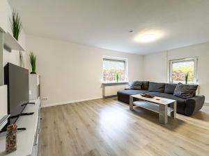 a living room with a couch and a table at Ferienhaus am Deich mit Küche, Balkon und Smart-TV in Emden