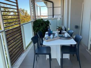 - Balcón con mesa blanca y sillas en Il Gioiello Del Borgo, en Borghetto Santo Spirito