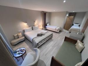 a hotel room with two beds and a couch at Le Chalet du Gîte de la Besnardière in Mareuil-sur-Cher
