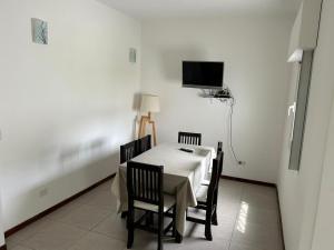 ein Esszimmer mit Tisch und Stühlen und einem Fernseher in der Unterkunft Villa Bono in Santa Clara del Mar