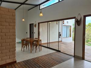 a dining room with a wooden table and glass doors at Casa Suíte À 800 Mts do Parq Chapada dos Veadeiros in Alto Paraíso de Goiás +67 photos