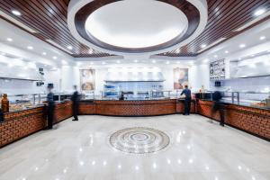 un ristorante con persone che stanno intorno a un bancone di David Dead Sea Resort & Spa a Ein Bokek Altre 37 foto