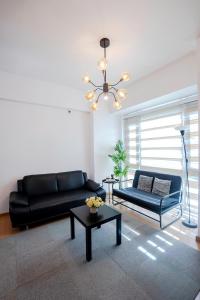 a living room with a black couch and a table at Premium 1BR unit at The Avant in Manila