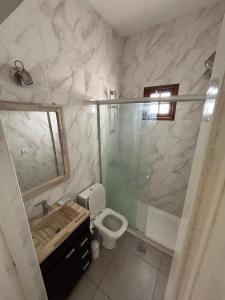 ein Badezimmer mit Dusche, Toilette und Waschbecken in der Unterkunft Villa Bono in Santa Clara del Mar