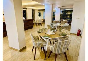 un ristorante con tavoli e sedie in una stanza di BluO Amani Vagator - Boutique Hotel Goa ad Anjuna