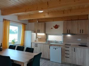 a kitchen with a wooden table and a table and chairs at Rekreační domky Nové Mlýny 17 - Pálava - in Milovice