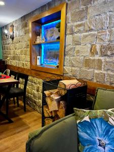 a living room with a couch and a stone wall at Вила Рози, Семково in Semkovo