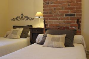 Chavagnes的住宿－老麵包店酒店，一间卧室设有两张床和砖墙