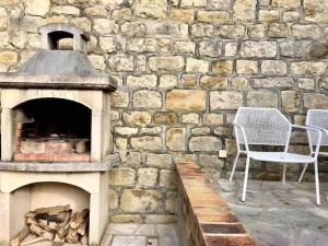 a stone wall with two chairs and an oven at Gîte La Maisonnette à Auvers-sur-Oise in Auvers-sur-Oise