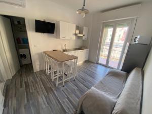 a kitchen with a table and a couch in a room at Soluzione Casa Pietra Ligure SEA VIEW in Pietra Ligure