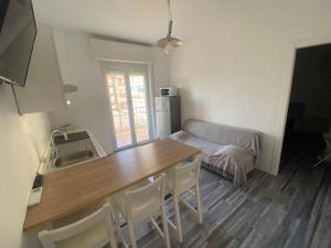 a kitchen with a table and a couch in a room at Soluzione Casa Pietra Ligure SEA VIEW in Pietra Ligure +4 photos