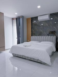 une chambre avec un grand lit blanc dans une pièce dans l'établissement AnJia Villa, à Pattaya (sud)